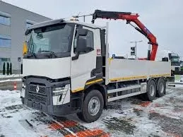 Ciężarówka z żurawiem HDS zaparkowana na śnieżnym placu przy budynku